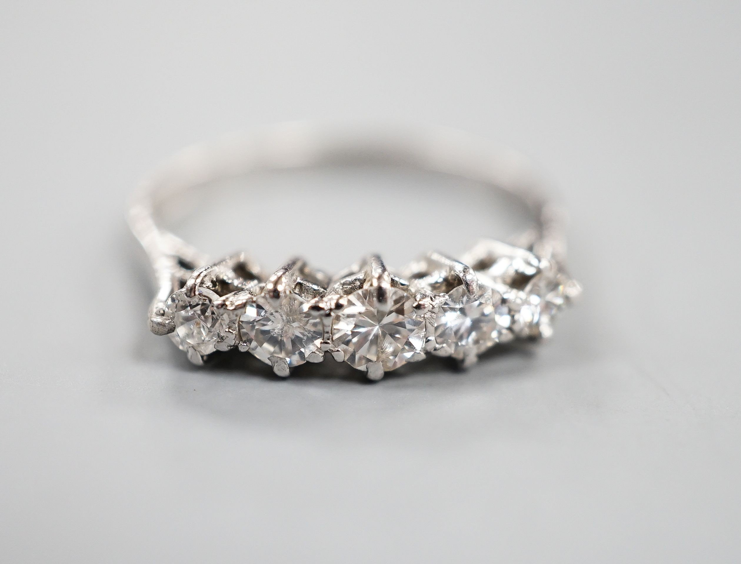 An 18ct white metal and graduated five stone diamond ring, size P/Q, gross weight 2.9 grams.